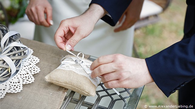 Hochzeitsfotograf Eventschloss Schönfeld - Bräutigam bindet Ehering von Ringkissen ab