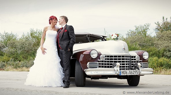 Hochzeitsfotograf Standesamt Greifswald - Brautpaar neben Hochzeitsauto