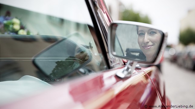 Hochzeitsfotograf Standesamt Barleben / Robinien-Hof Gommern - ein Brautlächeln im Autospiegel des Ford Mustang