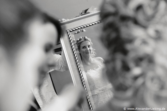 Hochzeit - letzte Vorbereitungen und getting ready Hochzeitsfotograf Eventschloss Schönfeld - Braut steht vor dem Spiegel