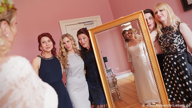 Hochzeit - letzte Vorbereitungen und getting ready Hochzeitsfotograf Eventschloss Schönfeld - Freunde halten den Spiegel für Braut