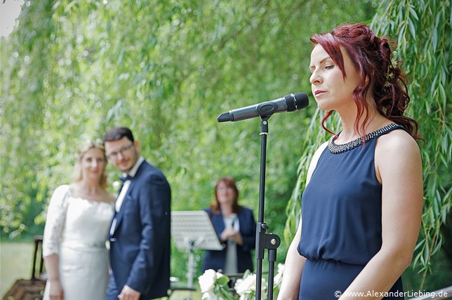 Hochzeit - Hochzeit, freie Trauung Hochzeitsfotograf Eventschloss Schönfeld - Frau steht am Mikrofon und singt