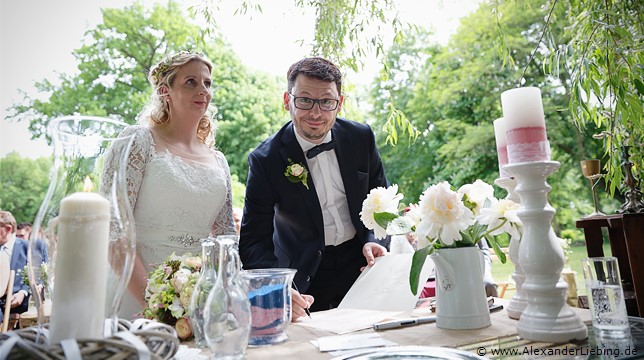 Hochzeitsfotograf Eventschloss Schönfeld - Bräutigam unterschreibt Hochzeitspapiere