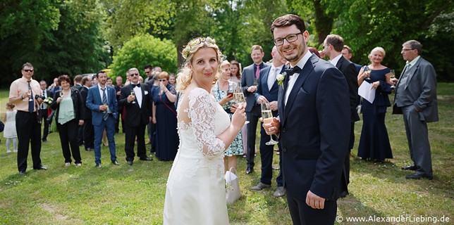 Hochzeit - Begrüßung, Sektempfang und Spielereien Hochzeitsfotograf Eventschloss Schönfeld - Mit einem Sekt wird auf das Ehepaar angestoßen
