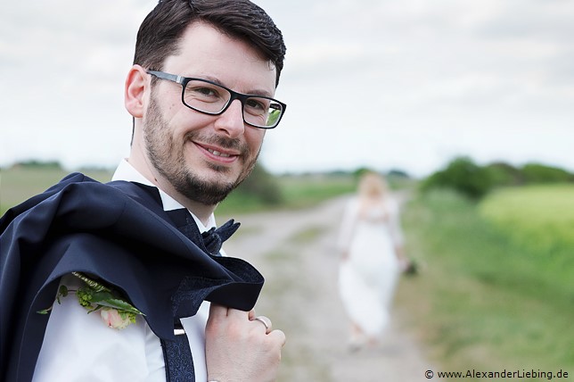 Hochzeit - Brautpaar Hochzeitsfotograf Eventschloss Schönfeld - Der Bräutigam mit Sakko über der Schulter