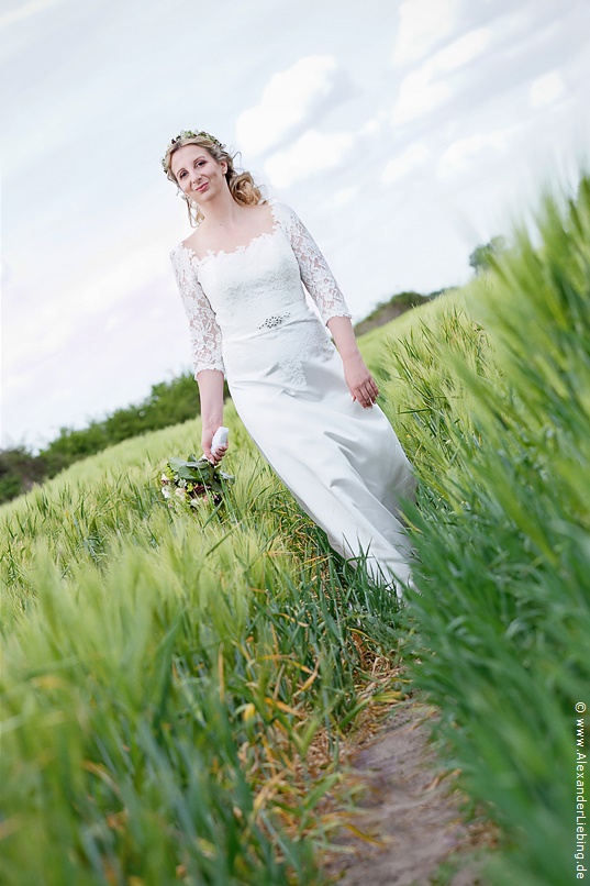 Hochzeit - Brautpaar Hochzeitsfotograf Eventschloss Schönfeld - Braut kommt auf Wiese entgegen