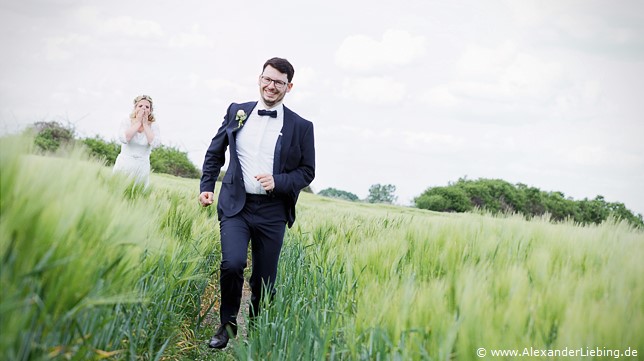 Hochzeit - Brautpaar Hochzeitsfotograf Eventschloss Schönfeld - Bräutigam rennt über die Wiese