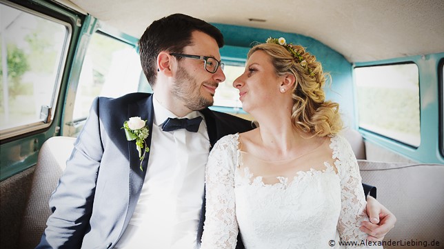 Hochzeit - Brautpaar Hochzeitsfotograf Eventschloss Schönfeld - Braut und Bräutigam sitzen im alten Omnibus