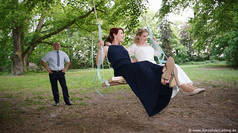 Hochzeit - Brautpaar Hochzeitsfotograf Eventschloss Schönfeld - Schaukeln im Schlosspark