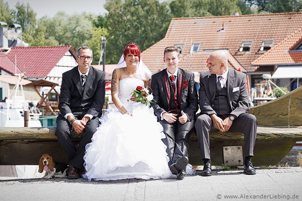 Hochzeit - Brautpaar Hochzeitsfotograf Standesamt Greifswald - alle sitzen auf der Bank