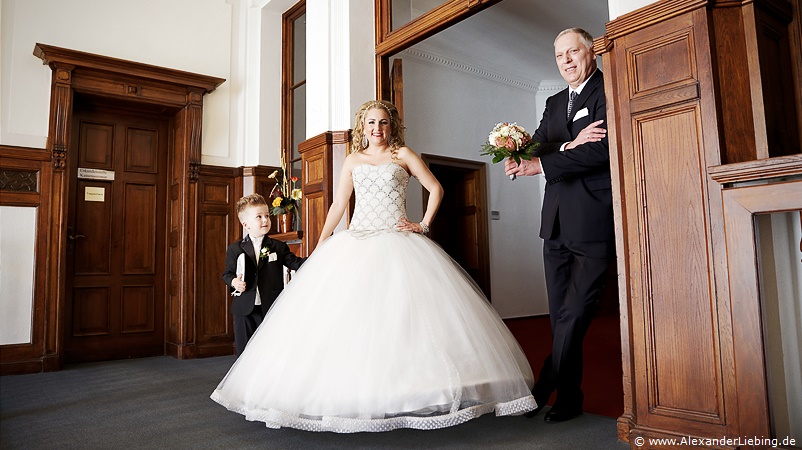 Hochzeit - kurz vor der Trauung Hochzeitsfotograf Standesamt Magdeburg / Gartenhaus im Stadtpark - Brautvater,Braut und Sohn stehen in Türrahmen