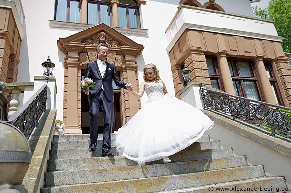 Hochzeit - Begrüßung, Sektempfang und Spielereien Hochzeitsfotograf Standesamt Magdeburg / Gartenhaus im Stadtpark - Ehepaar kommt die Treppe runter