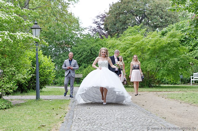 Hochzeit - Begrüßung, Sektempfang und Spielereien Hochzeitsfotograf Standesamt Magdeburg / Gartenhaus im Stadtpark - Braut und Trauzeugen auf dem Weg