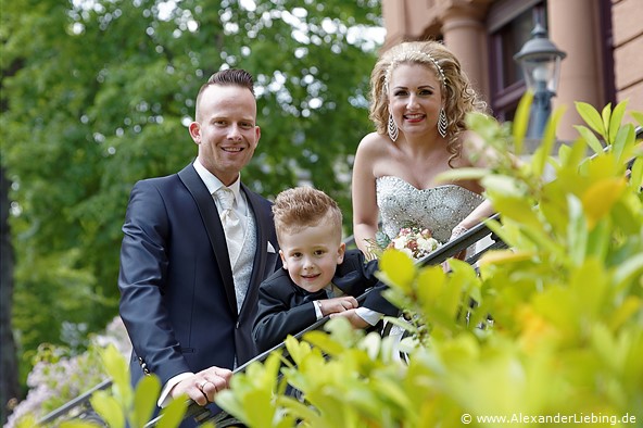 Hochzeit - Brautpaar Hochzeitsfotograf Standesamt Magdeburg / Gartenhaus im Stadtpark - kleine Familie guckt übers Geländer
