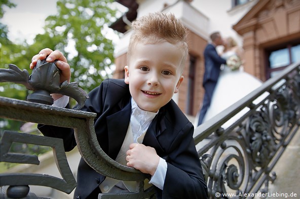 Hochzeit - Brautpaar Hochzeitsfotograf Standesamt Magdeburg / Gartenhaus im Stadtpark - Junge lehnt sich über Geländer