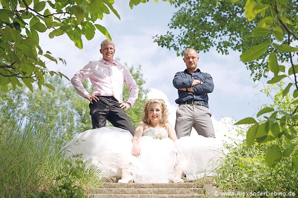 Hochzeit - Brautpaar Hochzeitsfotograf Standesamt Magdeburg / Gartenhaus im Stadtpark - Braut sitzt auf Treppe und Trauzeugen stehen dahinter