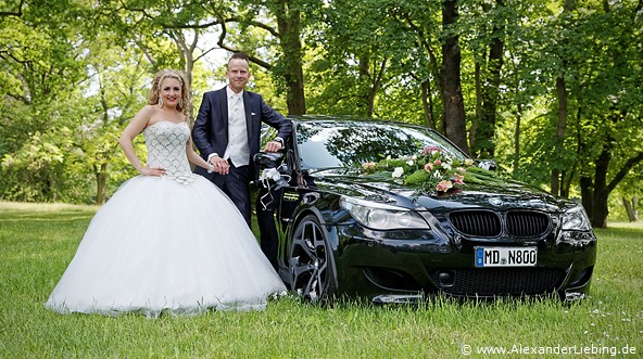 Hochzeitsfotograf Standesamt Magdeburg / Gartenhaus im Stadtpark - Ehepaar steht neben BMW