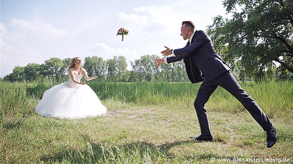 Hochzeit - Brautpaar Hochzeitsfotograf Standesamt Magdeburg / Gartenhaus im Stadtpark - Bräutigam wirft Braut Brautstrauß zu
