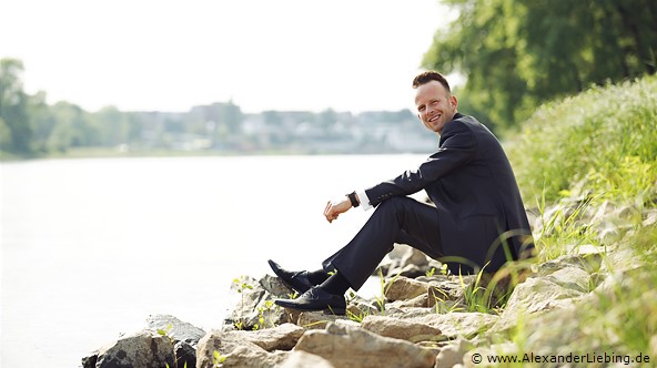 Hochzeit - Brautpaar Hochzeitsfotograf Standesamt Magdeburg / Gartenhaus im Stadtpark - Bräutigam sitzt am Ufer der Elbe