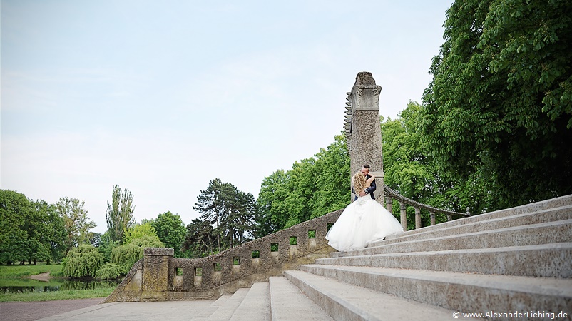 Hochzeitsfotograf Standesamt Magdeburg / Gartenhaus im Stadtpark - Brautpaar küsst sich oben auf Treppe