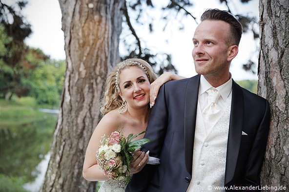 Hochzeit - Brautpaar Hochzeitsfotograf Standesamt Magdeburg / Gartenhaus im Stadtpark - Braut schaut über Schulter von Bräutigam