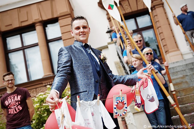 Hochzeit - Begrüßung, Sektempfang und Spielereien Hochzeitsfotograf Standesamt Magdeburg / Elbelandhaus - Bräutigam mit Wäscheleine