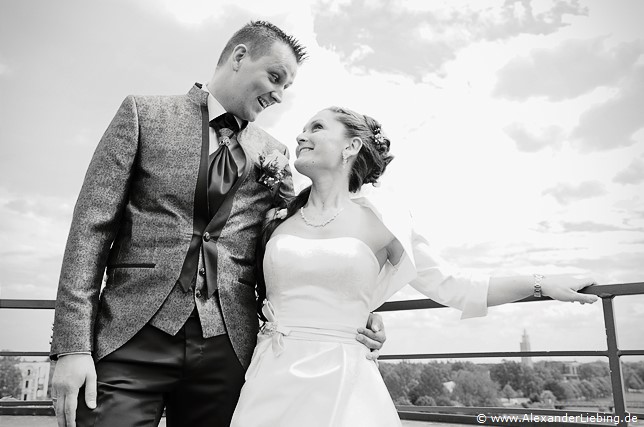 Hochzeit - Brautpaar Hochzeitsfotograf Standesamt Magdeburg / Elbelandhaus - Brautpaar steht auf einem Balkon und freut sich