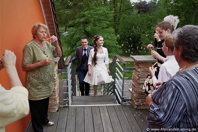 Hochzeit - Kaffee und Kuchen Hochzeitsfotograf Standesamt Magdeburg / Elbelandhaus - Gäste begrüßen das Brautpaar im Elbelandhaus mit Seifenblasen