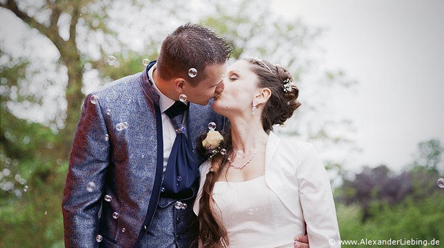 Hochzeit - Kaffee und Kuchen Hochzeitsfotograf Standesamt Magdeburg / Elbelandhaus - überall Seifenblasen, Brautpaar küßt sich