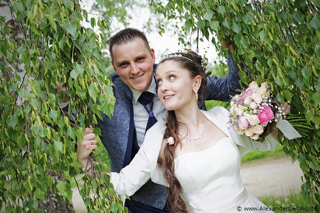 Hochzeitsfotograf Standesamt Magdeburg / Elbelandhaus - Braut schaut Bräutigam durch Birke an