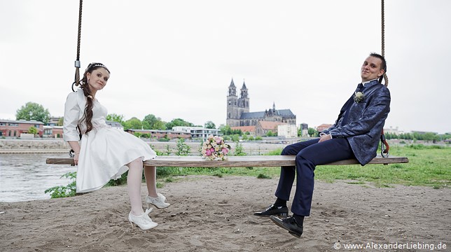 Hochzeitsfotograf Standesamt Magdeburg / Elbelandhaus - zwischen Braut und Bräutigam liegt Brautstrauß auf Elbschaukel