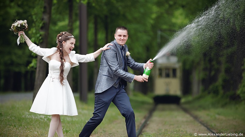 Hochzeitsfotograf Standesamt Magdeburg / Elbelandhaus - Brautpaar hat Spaß bei Sektdusche.