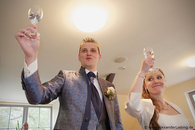 Hochzeit - Hochzeitsfeier Hochzeitsfotograf Standesamt Magdeburg / Elbelandhaus - Ehepaar hält Sektklas in der Hand