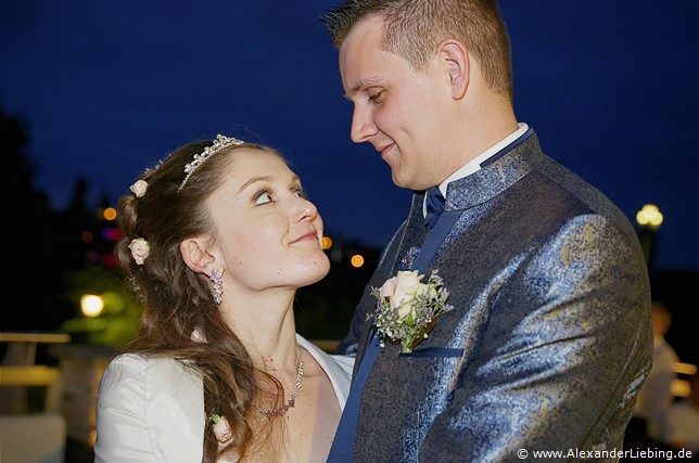 Hochzeit - Hochzeitsfeier Hochzeitsfotograf Standesamt Magdeburg / Elbelandhaus - Brautpaar schaut sich im strahlenden Blau des Nachthimmels in die Augen.