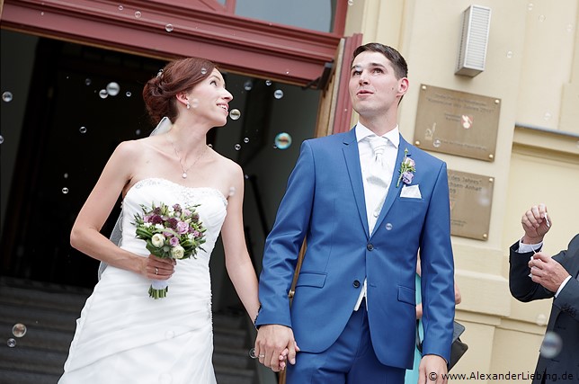Hochzeit - Begrüßung, Sektempfang und Spielereien Hochzeitsfotograf Standesamt Barleben / Robinien-Hof Gommern - die Gäste empfangen vor dem Standesamt das Brautpaar mit Seifenblasen