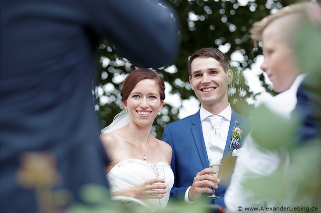 Hochzeit - Begrüßung, Sektempfang und Spielereien Hochzeitsfotograf Standesamt Barleben / Robinien-Hof Gommern - Ehepaar in mitten ihrer Gäste beim Sektempfang