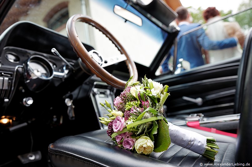 Hochzeit - Hochzeitsfeier Hochzeitsfotograf Standesamt Barleben / Robinien-Hof Gommern - Nahaufnahme vom Brautstrauß auf Autositz des Ford Mustang