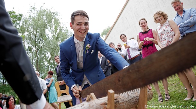Hochzeit - Hochzeitsfeier Hochzeitsfotograf Standesamt Barleben / Robinien-Hof Gommern - ein alöter Brauch ist das Baumstammsägen