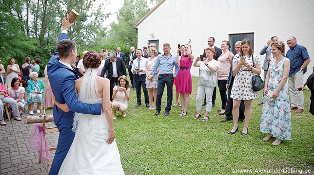 Hochzeitsfotograf Standesamt Barleben / Robinien-Hof Gommern - stolz präsentiert der Bräutigam eine Hälfte des Baumstamms