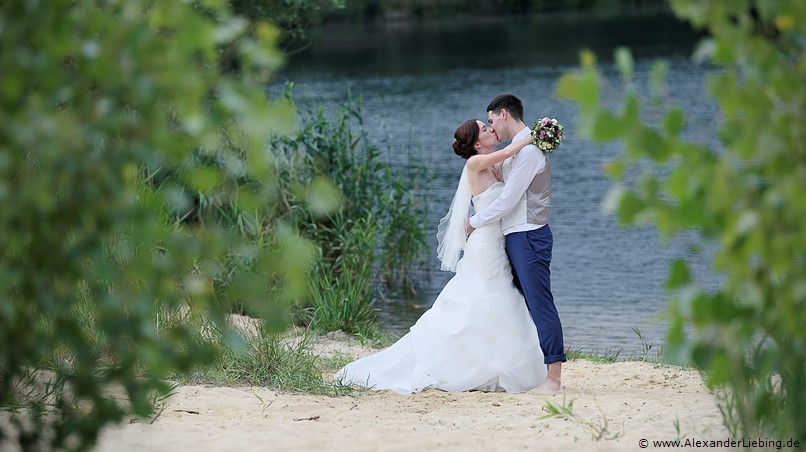 Hochzeit - Brautpaar Hochzeitsfotograf Standesamt Barleben / Robinien-Hof Gommern - Seebilder: Brautpaar küsst sich am Kulk-Strand in Gommern