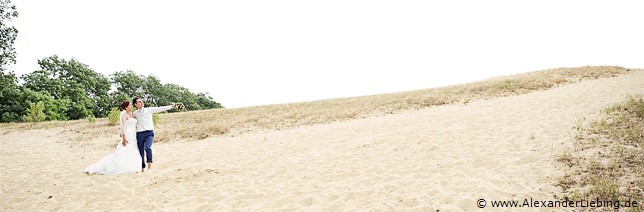 Hochzeit - Brautpaar Hochzeitsfotograf Standesamt Barleben / Robinien-Hof Gommern - Bräutigam zeigt seiner Braut etwas im Sand am Kulk