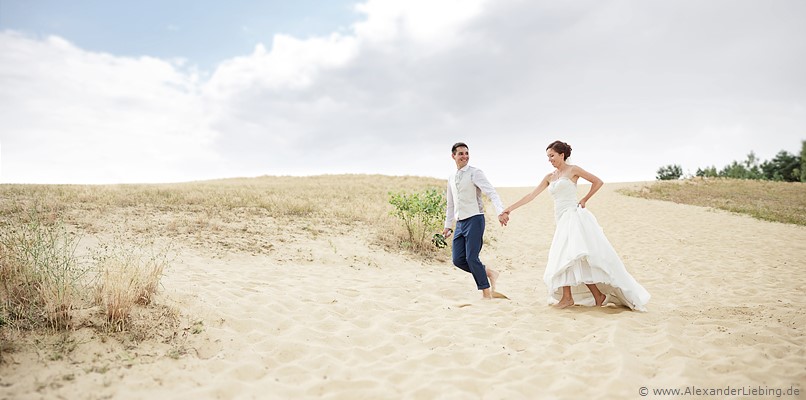 Hochzeit - Brautpaar Hochzeitsfotograf Standesamt Barleben / Robinien-Hof Gommern - Brautpaar läuft über den Sand
