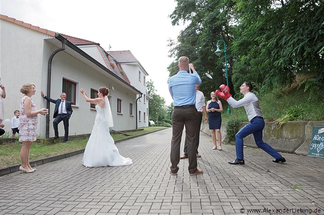 Hochzeit - Hochzeit, Poltern Hochzeitsfotograf Standesamt Barleben / Robinien-Hof Gommern - der Bräutigam muss die handbeschriebenen Teller mit Boxhandschuhen auffangen