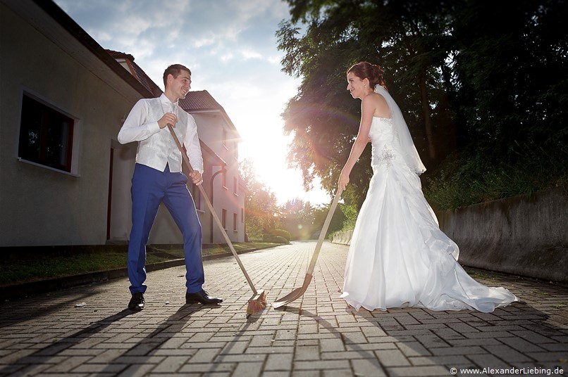 Hochzeitsfotograf Standesamt Barleben / Robinien-Hof Gommern - das Brautpaar fegt Scherben zusammen