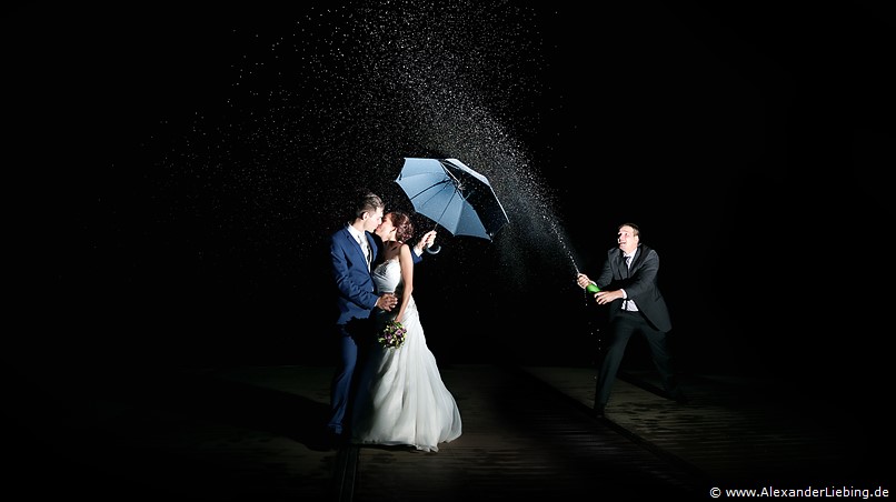 Hochzeitsfotograf Standesamt Barleben / Robinien-Hof Gommern - auch Mittwernacht lassen sich tolle Bilder vom Brautpaar machen, hier stehen beide entspannt mit Schirm im Sektregen