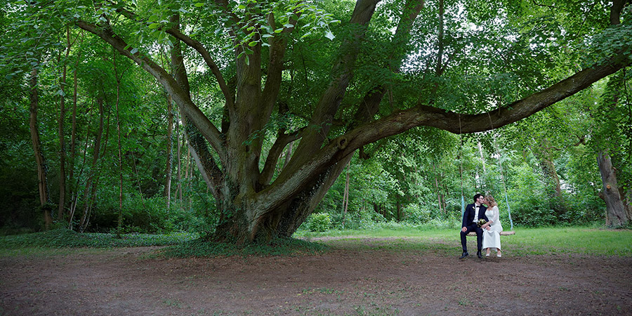 Ein glückliches Brautpaar läuft durch die Heide